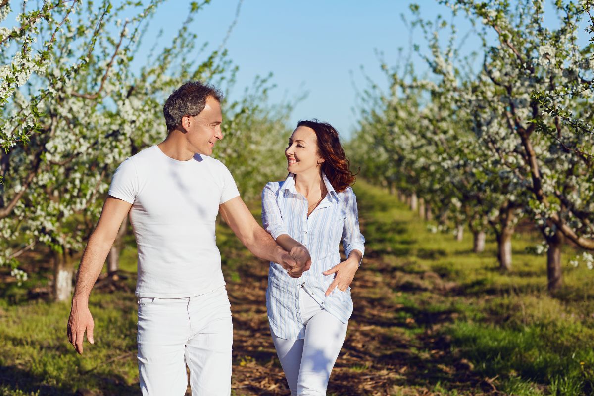 Middle aged couple walking through vineyard