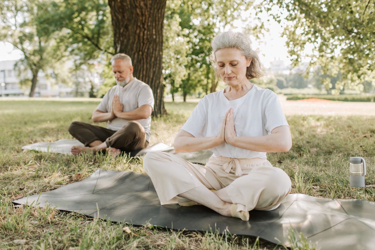 Mature aged couple doing yoga outdoors
